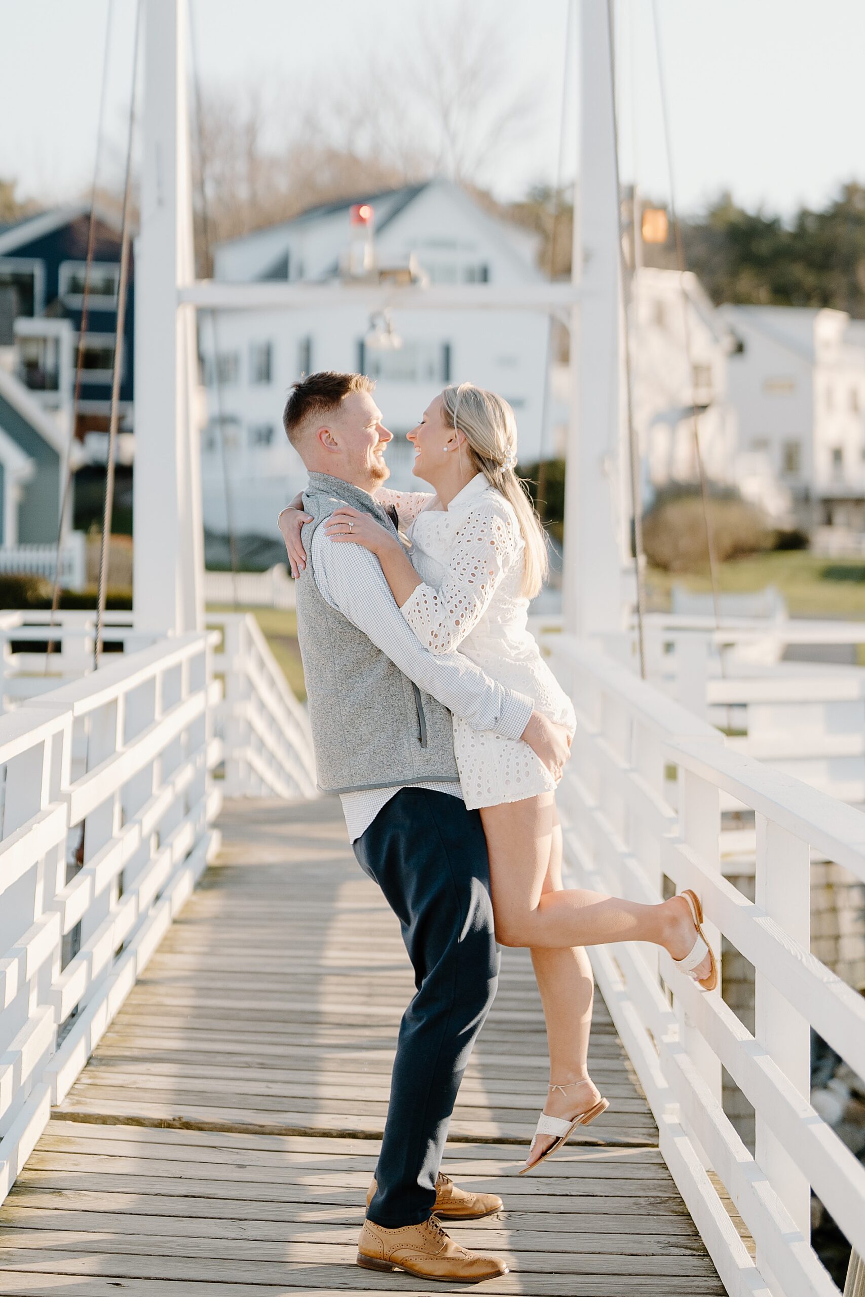 guy lifts his fiance up on dock 