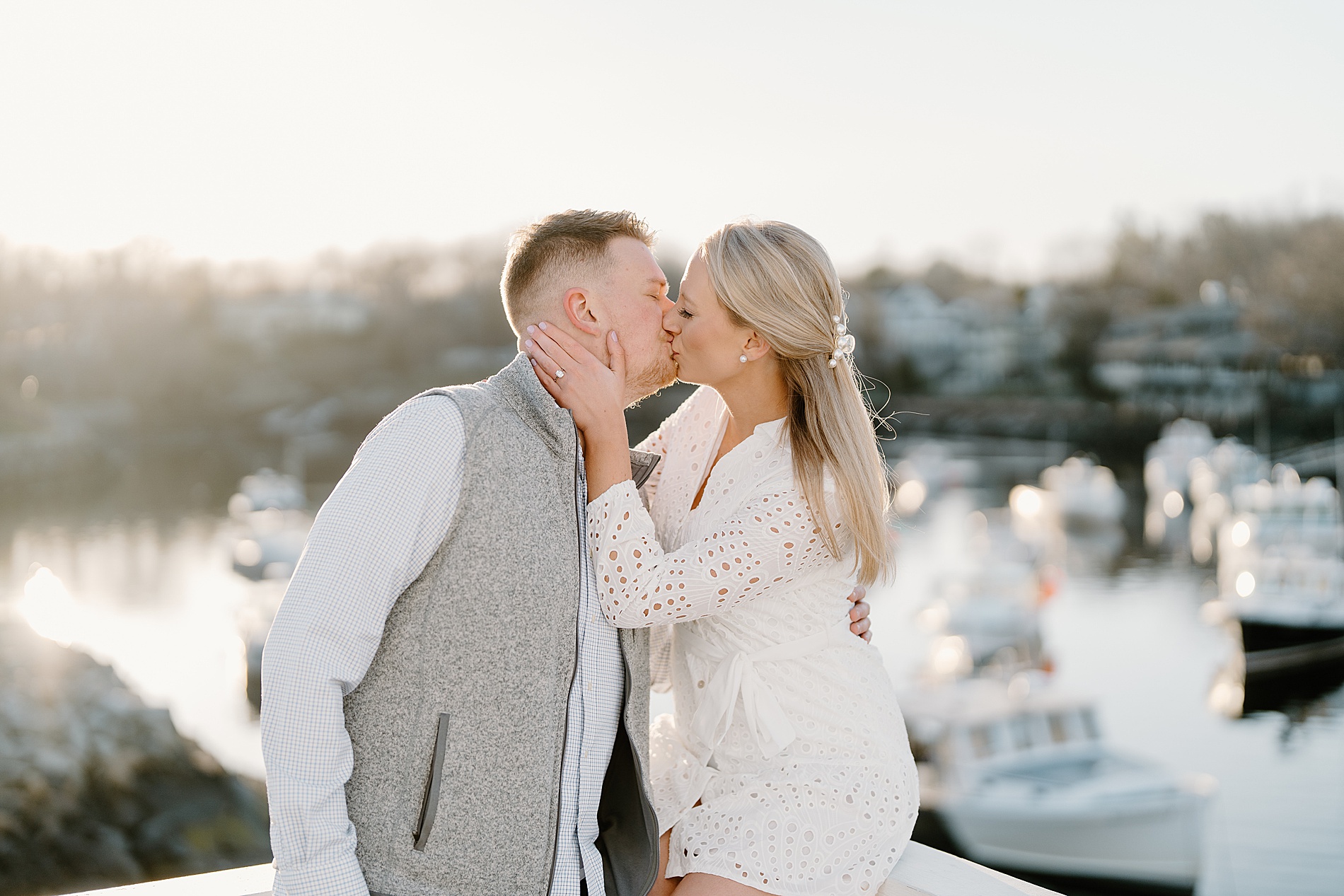engaged couple kiss near water