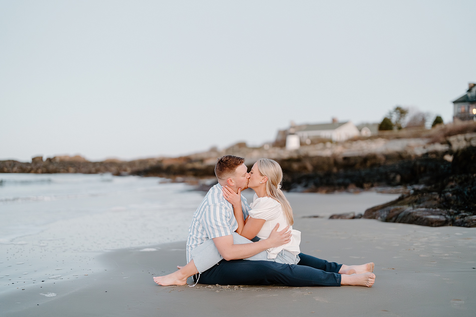 couple kiss sitting together on the beach