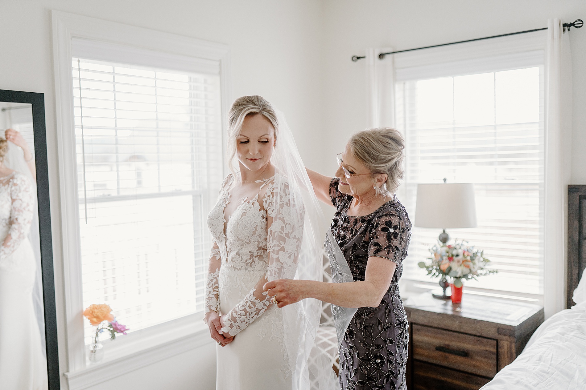 mom helps daughter into wedding dress