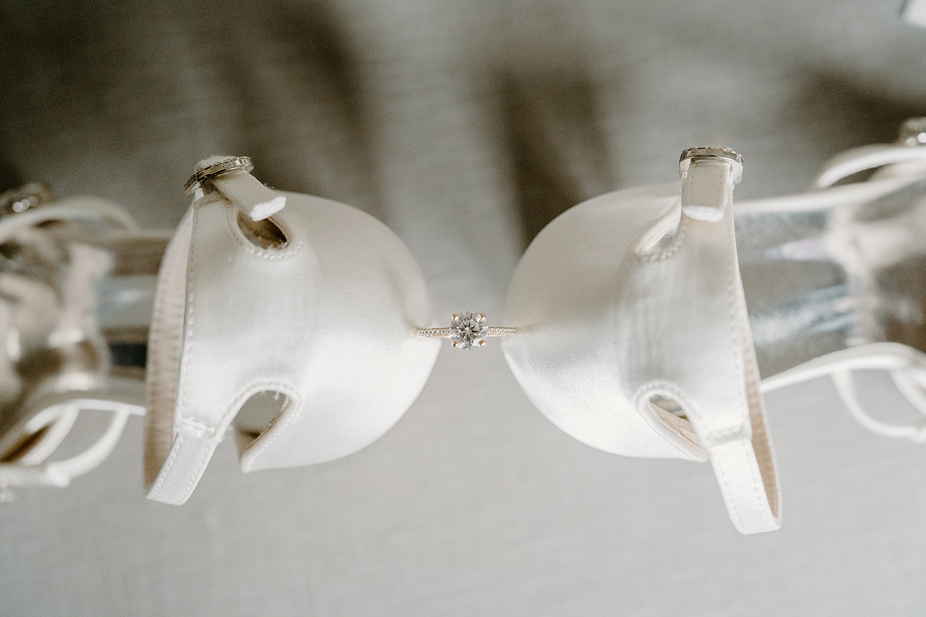 wedding ring in between bride's shoes