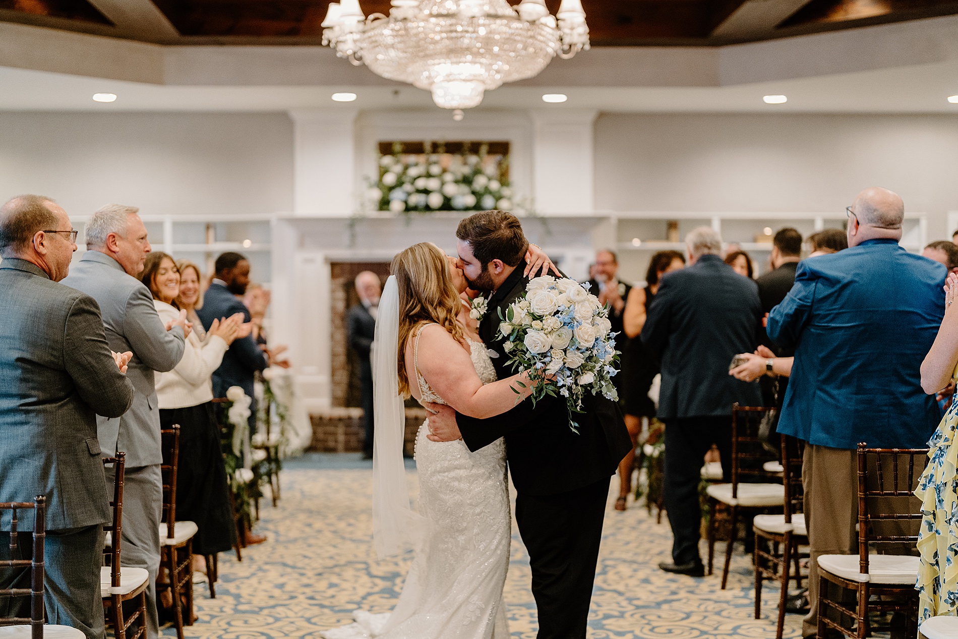 couple kiss as they exit wedding ceremony